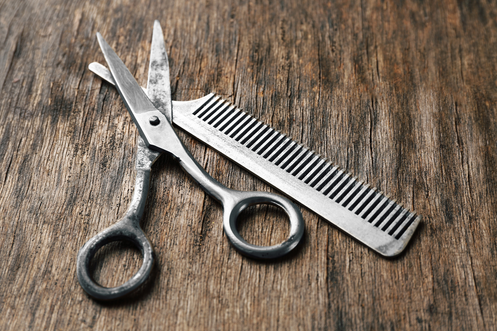 Vintage Scissors and Comb on Wooden Background